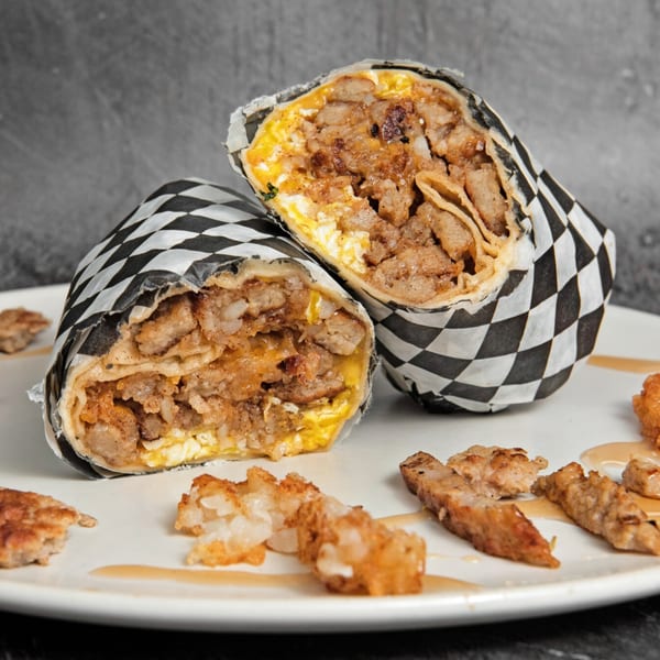 Two Mitchell's breakfast burritos, cut in half, revealing eggs, sausage, and hash browns.